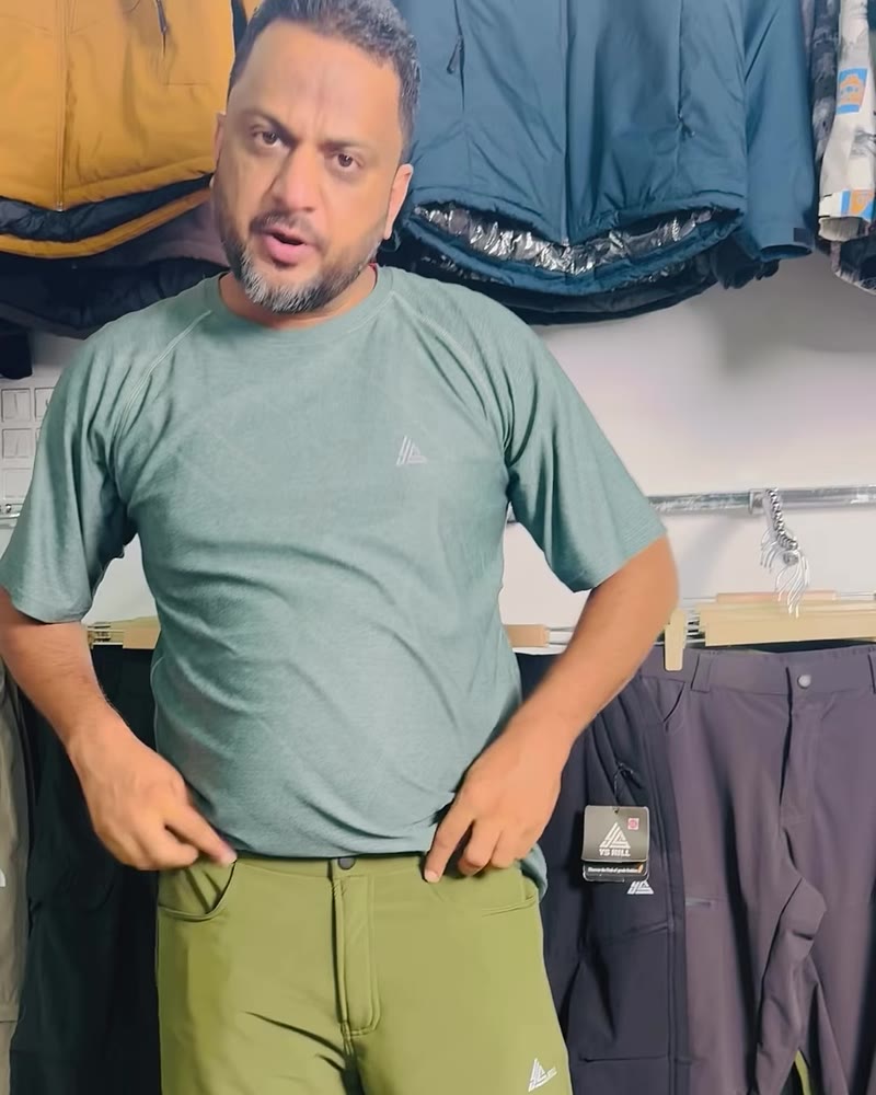 Man in a teal green YS Hill t-shirt with the triangle chest logo